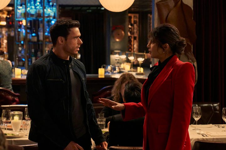 Richard Madden and Priyanka Chopra Jonas face each other in a restaurant in Citadel.