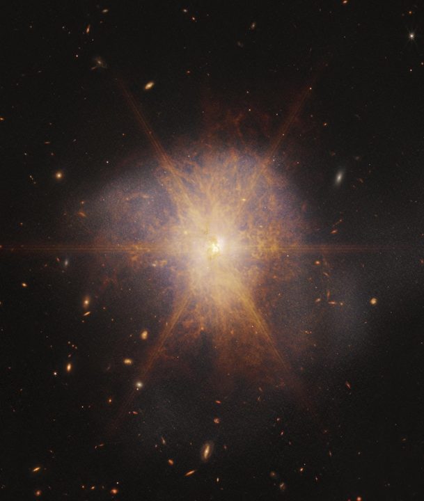 Shining like a brilliant beacon amidst a sea of galaxies, Arp 220 lights up the night sky in this view from NASA’s James Webb Space Telescope. Actually two spiral galaxies in the process of merging, Arp 220 glows brightest in infrared light, making it an ideal target for Webb. It is an ultra-luminous infrared galaxy (ULIRG) with a luminosity of more than a trillion suns. In comparison, our Milky Way galaxy has a much more modest luminosity of about ten billion suns.