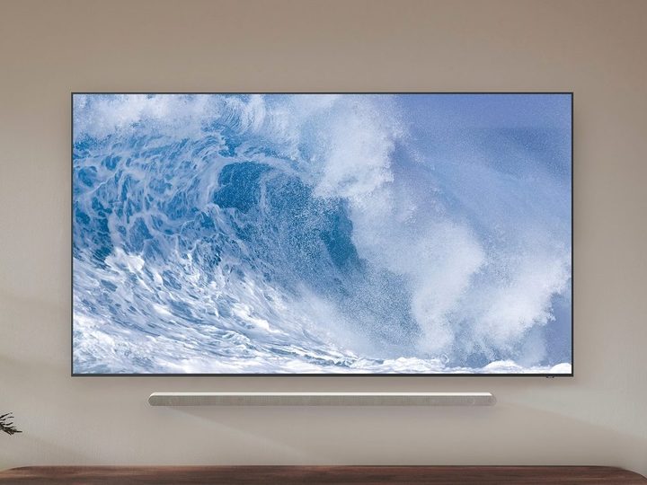 The Samsung QN700B QLED 8K TV with a wave on the screen, while mounted to a wall.