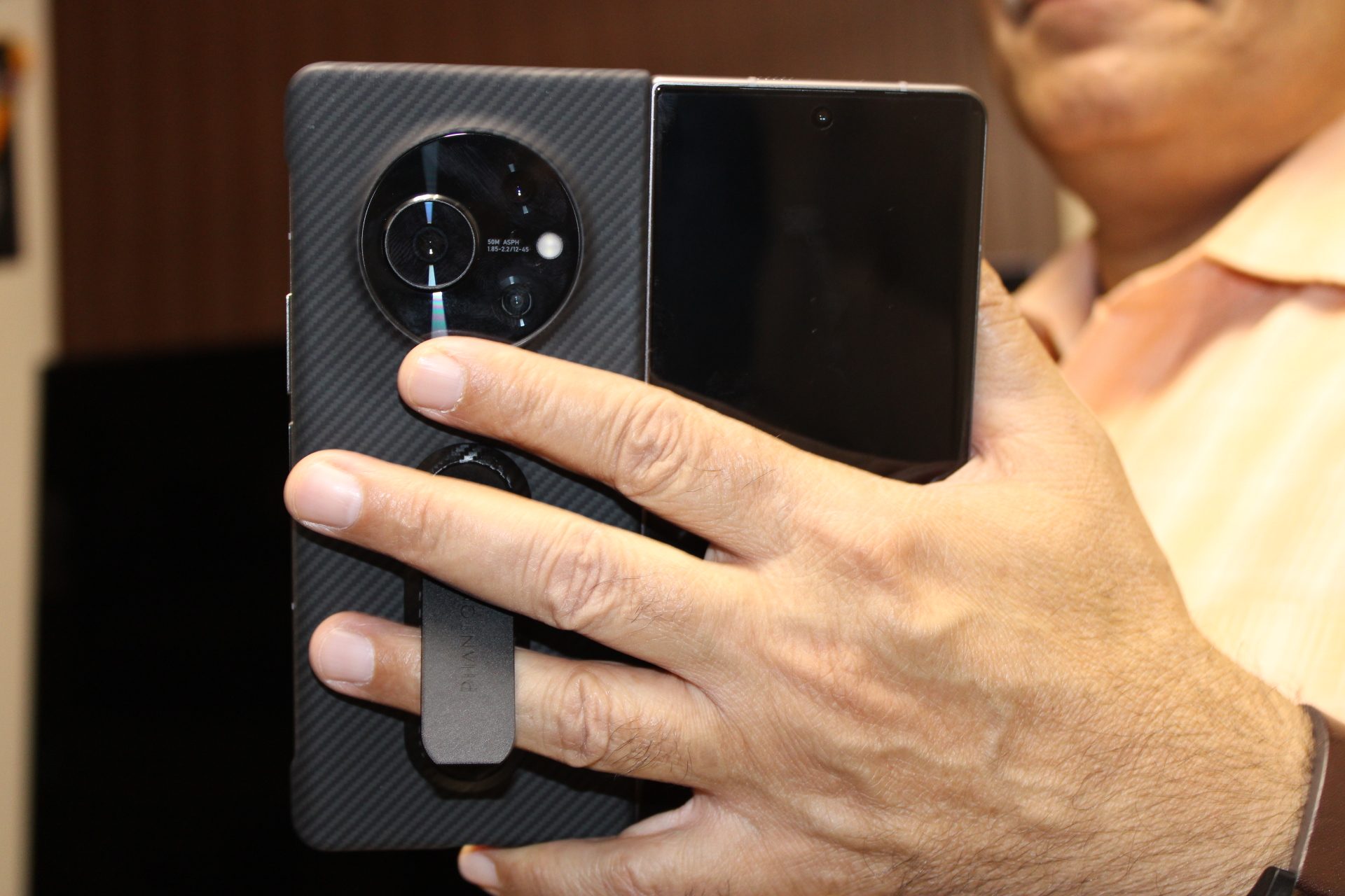 Holding the Tecno Phantom V Fold with its kickstand cover.