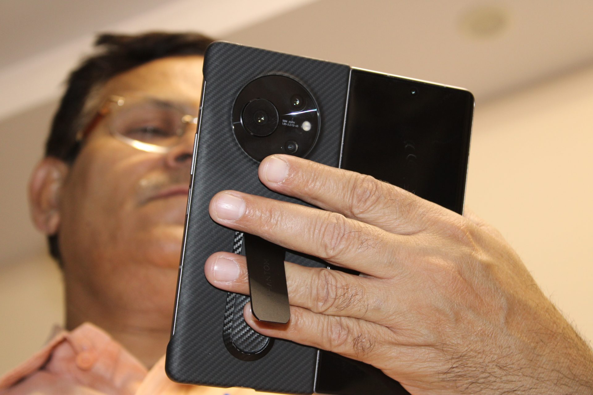 Holding the Tecno Phantom V Fold with its kickstand cover.