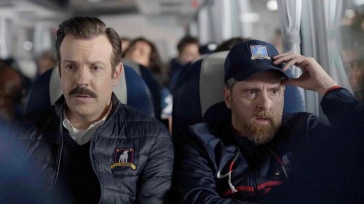 Ted and a man ride a bus in Ted Lasso season 3.