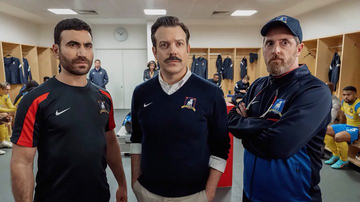 Ted and 2 men hang out in a locker room in Ted Lasso season 3.
