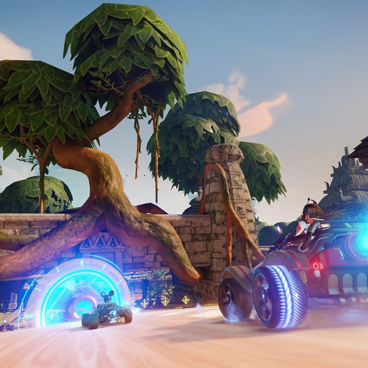 Karts race towards a tree in Disney Speedstorm.