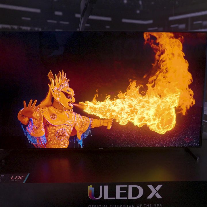 A performer in a dragon mask breathes fire displayed on the Hisense 85UX.