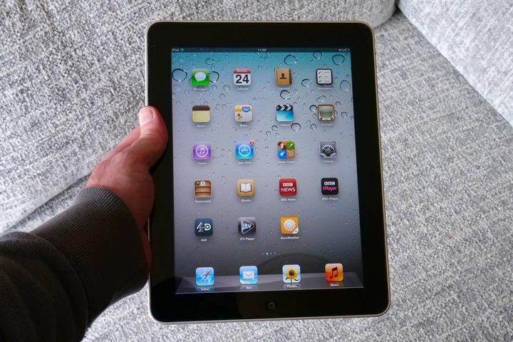 A person holding the original iPad, showing the screen.