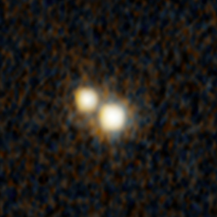 a hubble space telescope photograph of a pair of quasars that existed when the universe was just 3 billion years old. they are embedded inside a pair of colliding galaxies.
