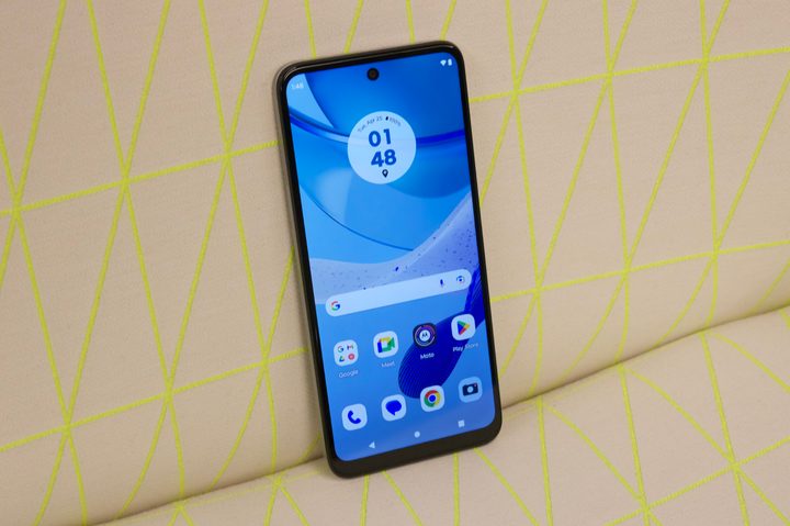 The Moto G 5G 2023 standing upright on a couch.