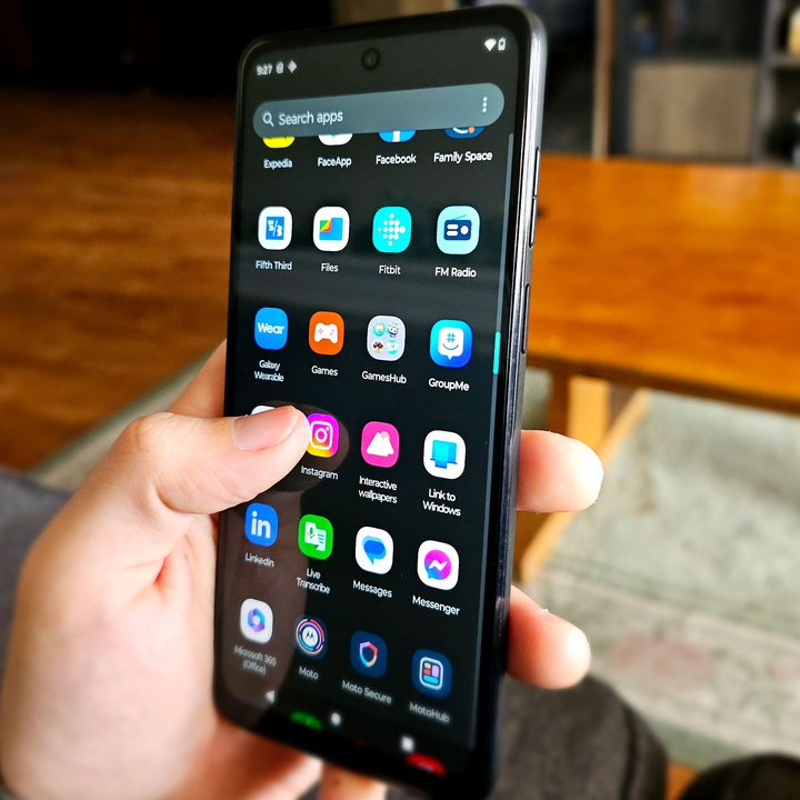 A hand scrolling through apps on the Moto G Power 5G.