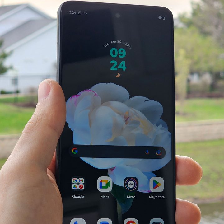 Someone holding the Moto G Power 5G outside, with the display on.