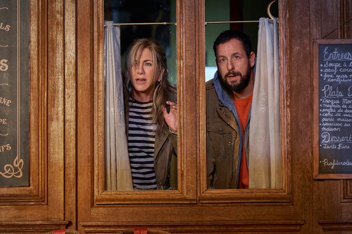 A man and a woman look out a window in Murder Mystery 2.