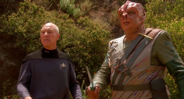 Picard and an alien stand outside in Star Trek: The Next Generation.