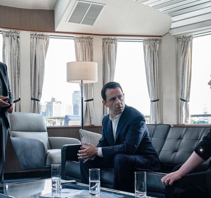 Three people talk in a room in Succession season 4.