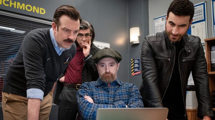 Four men look at a computer in Ted Lasso season 3.
