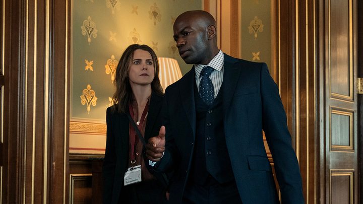 Kate locking arms with Austin in a scene from The Diplomat on Netflix.