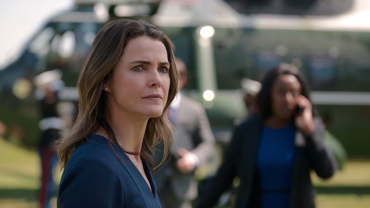 A close-up of Kate from The Diplomat on Netflix, the White House Chief of Staff on the phone in the background.