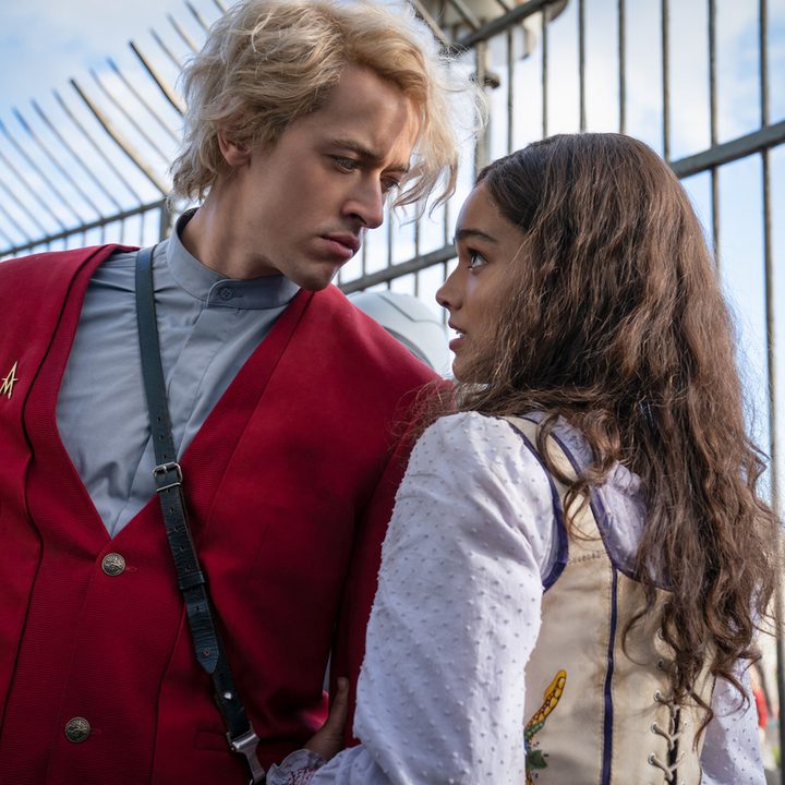 A boy looks into the eyes of a girl alongside a fence in The Hunger Games prequel.