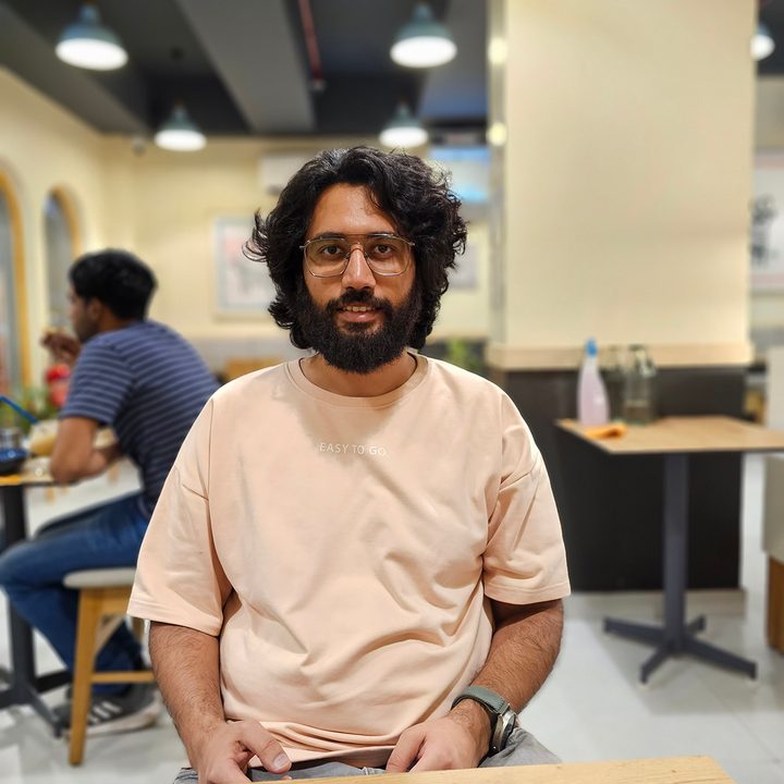 Portrait shot of a man sitting in a cafe captured by the Samsung Galaxy S23 Utra.