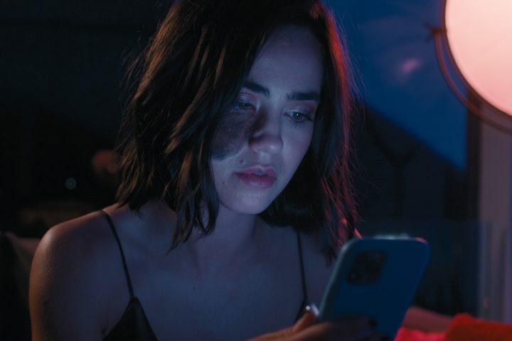 Cassandra Naud looks at a phone screen in Influencer.