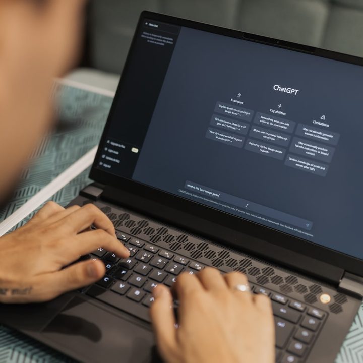 A person typing on a laptop that is showing the ChatGPT generative AI website.