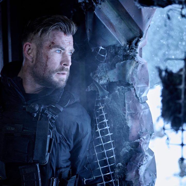 Chris Hemsworth stands against a wall in Extraction 2.