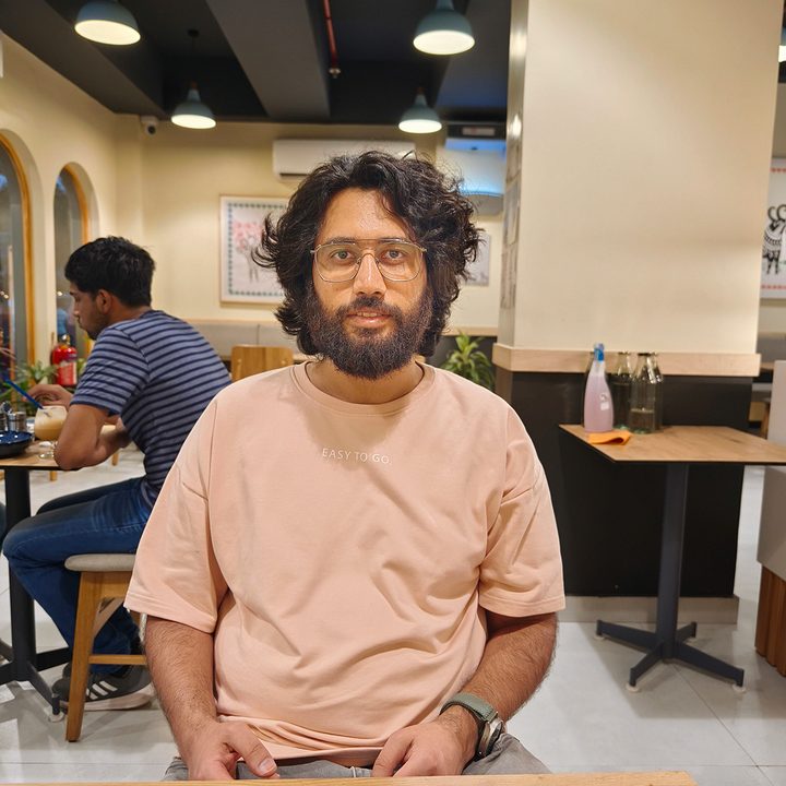 Portrait shot of a man sitting in a cafe captured by the Vivo X90 Pro.