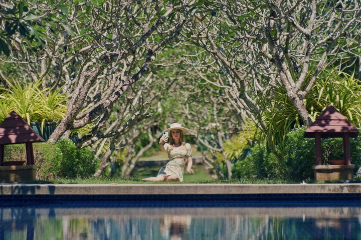 Emily Tennant takes a selfie near a pool in Influencer.