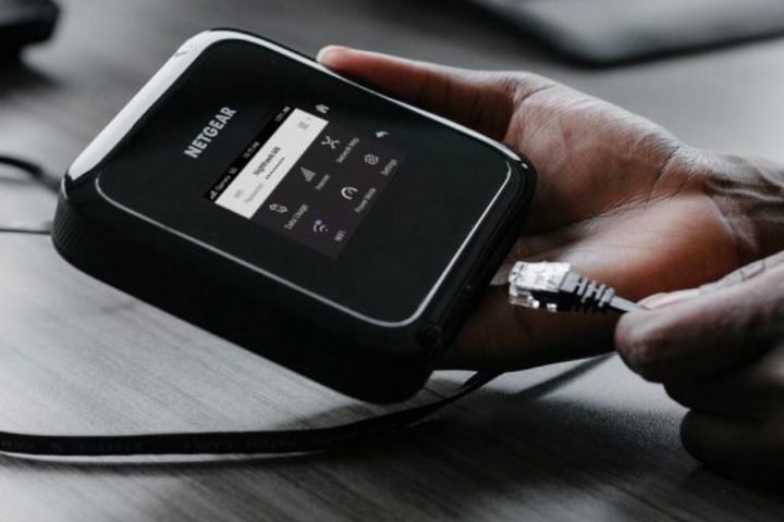 Person plugging an Ethernet cable into a Netgear M6 Pro Mobile Hotspot.