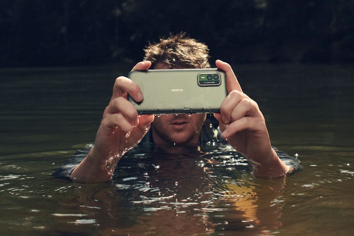 A person holding the Nokia XR21, while in water.
