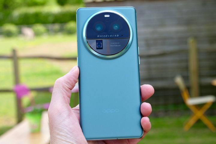 A person holding the Oppo Find X6 Pro, showing the back of the phone.