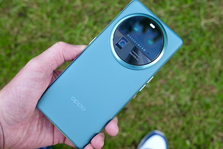 A person holding the Oppo Find X6 Pro, showing the back of the phone.