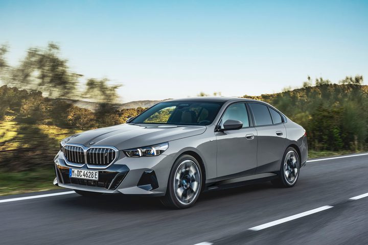 A 2024 BMW i5 on a road against an evening sky.