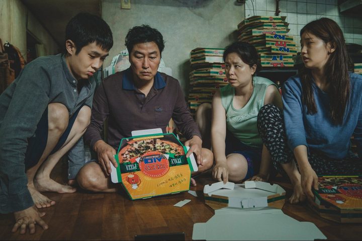 Kim Ki-taek with his family gathered together on the floor.