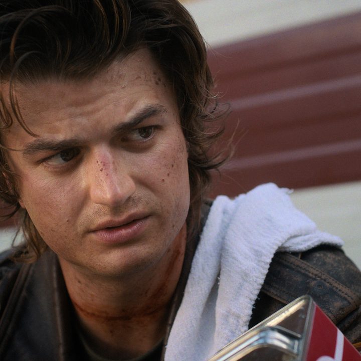 Joe Keery stairs with a towel over shoulder in Stranger Things.