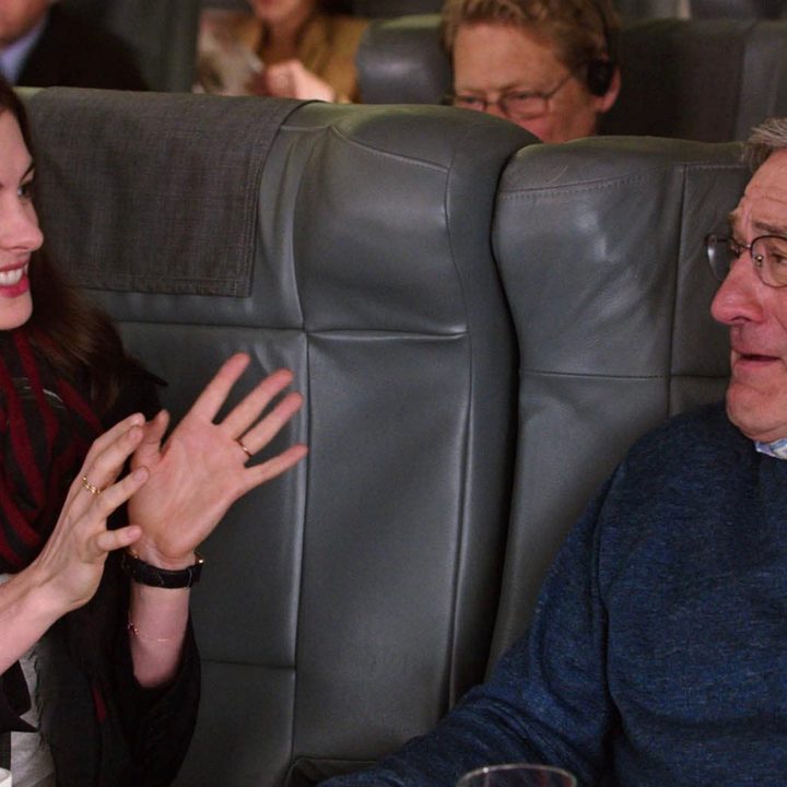 Anne Hathaway sits next to Robert De Niro on a plane.