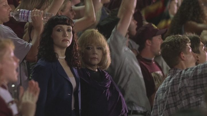 The faculty watch students at a football game in The Faculty.