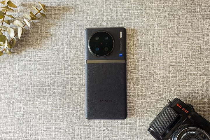 Vivo X90 Pro with Yashica analog camera on a flat surface.