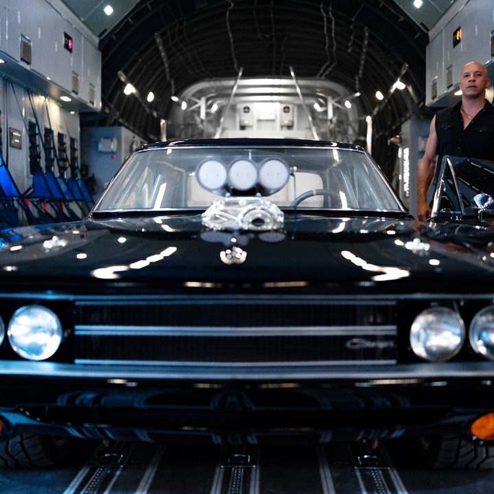 A man stands next to a car in Fast X.