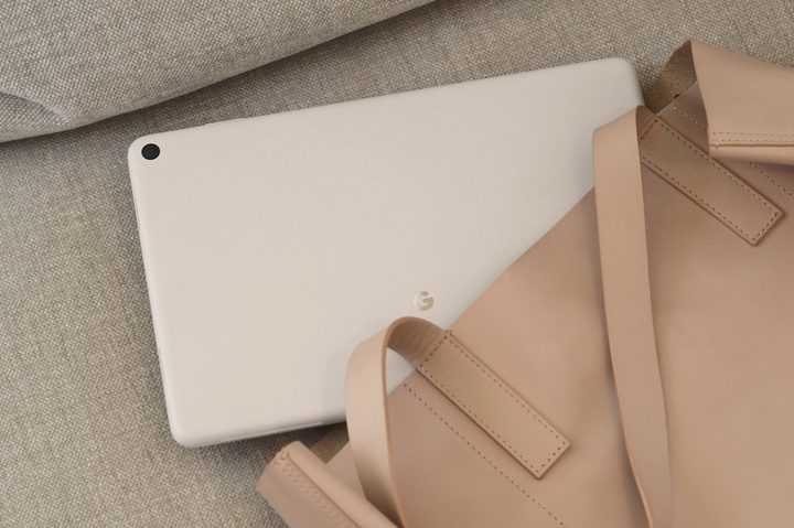 The Google Pixel Tablet lying on a couch, halfway in a purse.