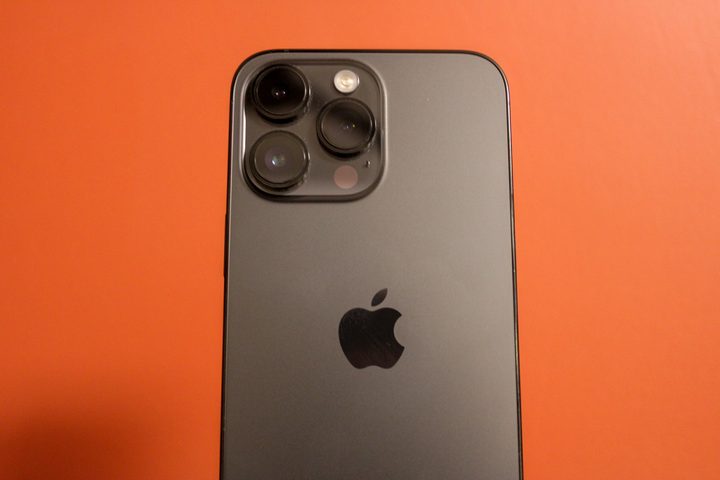 iPhone 14 Pro Max against a red background.
