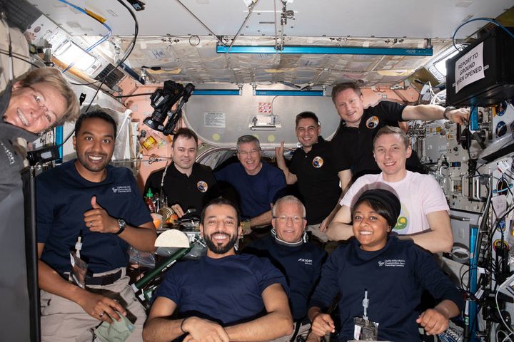 The Axiom Mission-2 and Expedition 69 crew members pose for a portrait together during dinner time aboard the International Space Station. In the center front row, is Expedition 69 crew member and UAE (United Arab Emirates) astronaut Sultan Alneyadi flanked by (from left) Axiom Mission-2 crew members Commander Peggy Whitson, Mission Specialist Ali Alqarni, Pilot John Shoffner, and Mission Specialist Rayyanah Barnawi. In the back (from left) are, Expedition 69 crew members Roscosmos cosmonaut Dmitri Petelin, NASA astronaut Stephen Bowen, Roscosmos cosmonauts Andrey Fedyaev and Sergey Prokopyev, and NASA astronaut Woody Hoburg. Not pictured is NASA astronaut Frank Rubio.