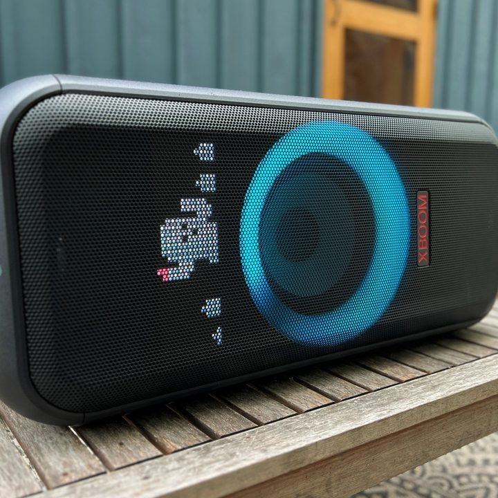 The LG XBoom XL7 portable party speaker laying horizontal on a table outdoors on a deck.