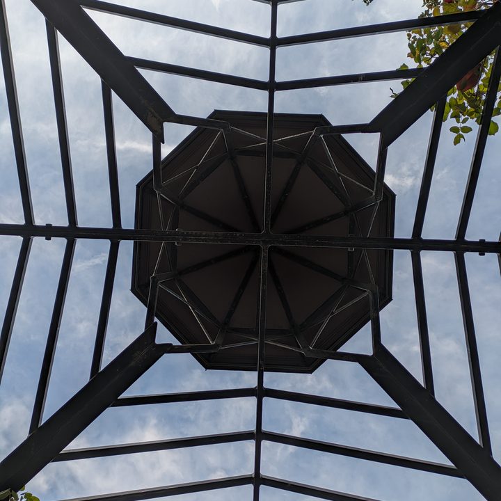 Metal canopy with sky peeking through taken with Google Pixel 7a main camera