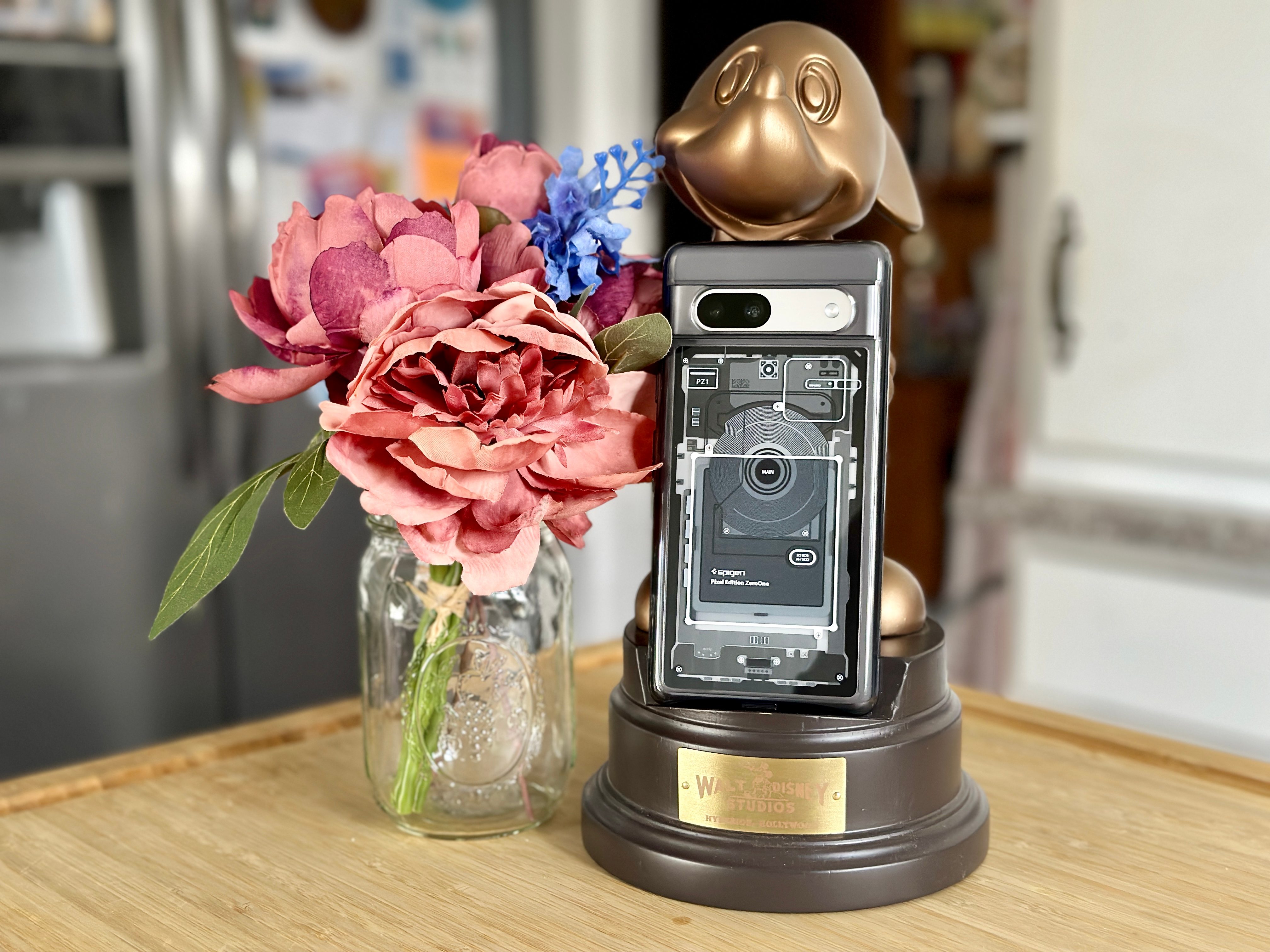Spigen Ultra Hybrid Zero One Pixel 7a case on a Mickey phone stand with flowers