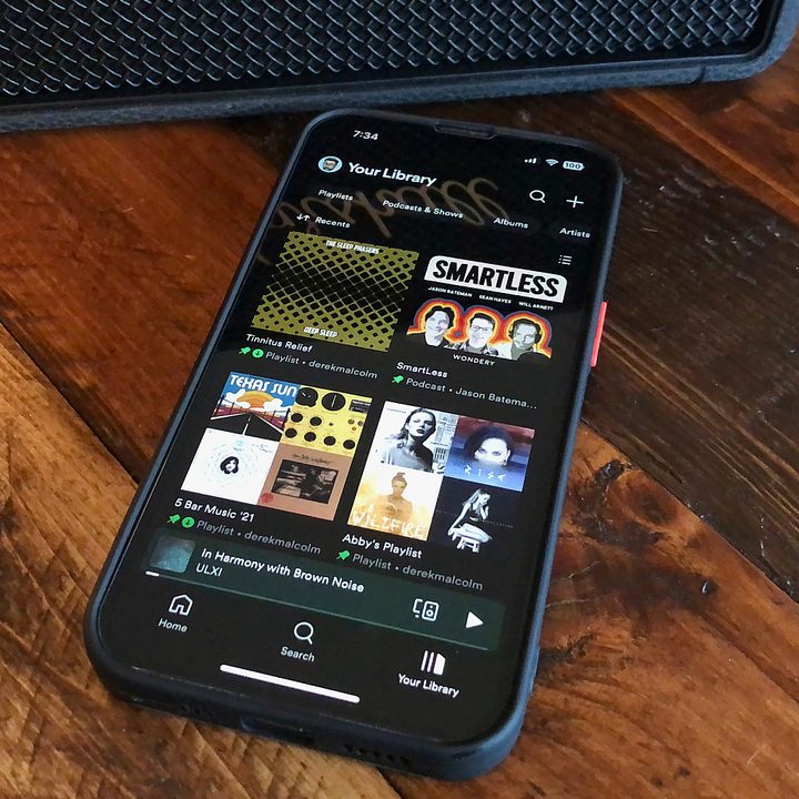 An iPhone with the Home section of the Spotify app on it.