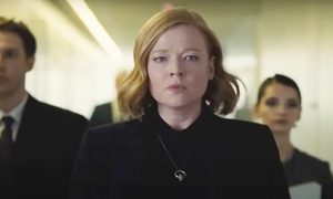 Shiv angry walking down a hallway with people behind her in a scene from Succession.
