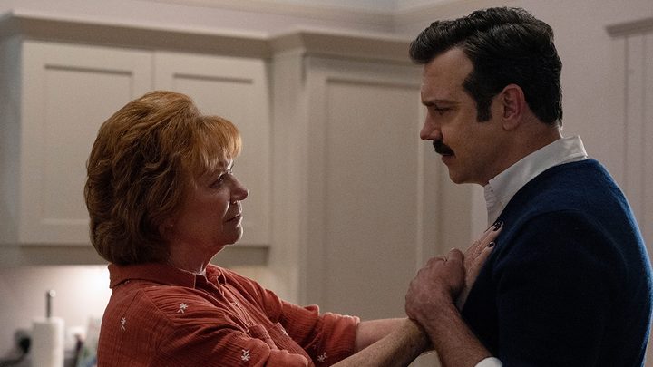 Ted's mom Dottie with her hands on his chest, him holding them in a scene from Ted Lasso.