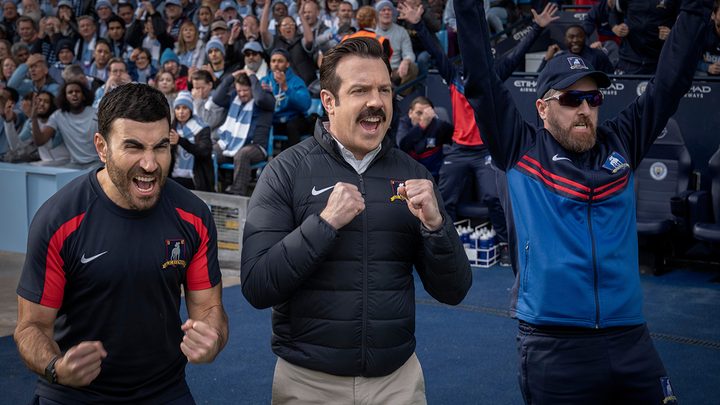 Three men cheer in Ted Lasso.