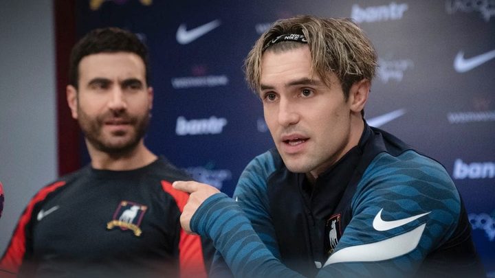 Two men attend a press conference in Ted Lasso season 3.