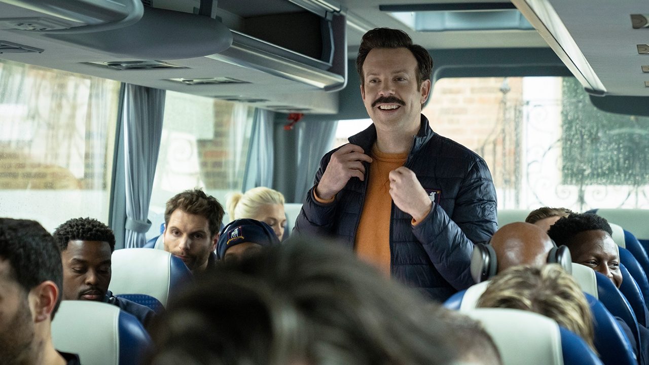 Ted smiling on a bus on Ted Lasso.